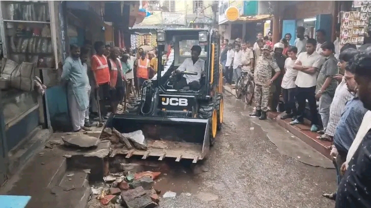 झरिया में नगर निगम का बुलडोजर एक्शन, गांधी रोड से हटाया गया नालियों पर अतिक्रमण