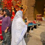 धनबाद: मोबाइल कैमरों के बीच आंचल फैलाकर मां दुर्गा से परिवार की खुशियां मांगती दिखीं बुजुर्ग महिला