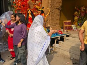 धनबाद: मोबाइल कैमरों के बीच आंचल फैलाकर मां दुर्गा से परिवार की खुशियां मांगती दिखीं बुजुर्ग महिला